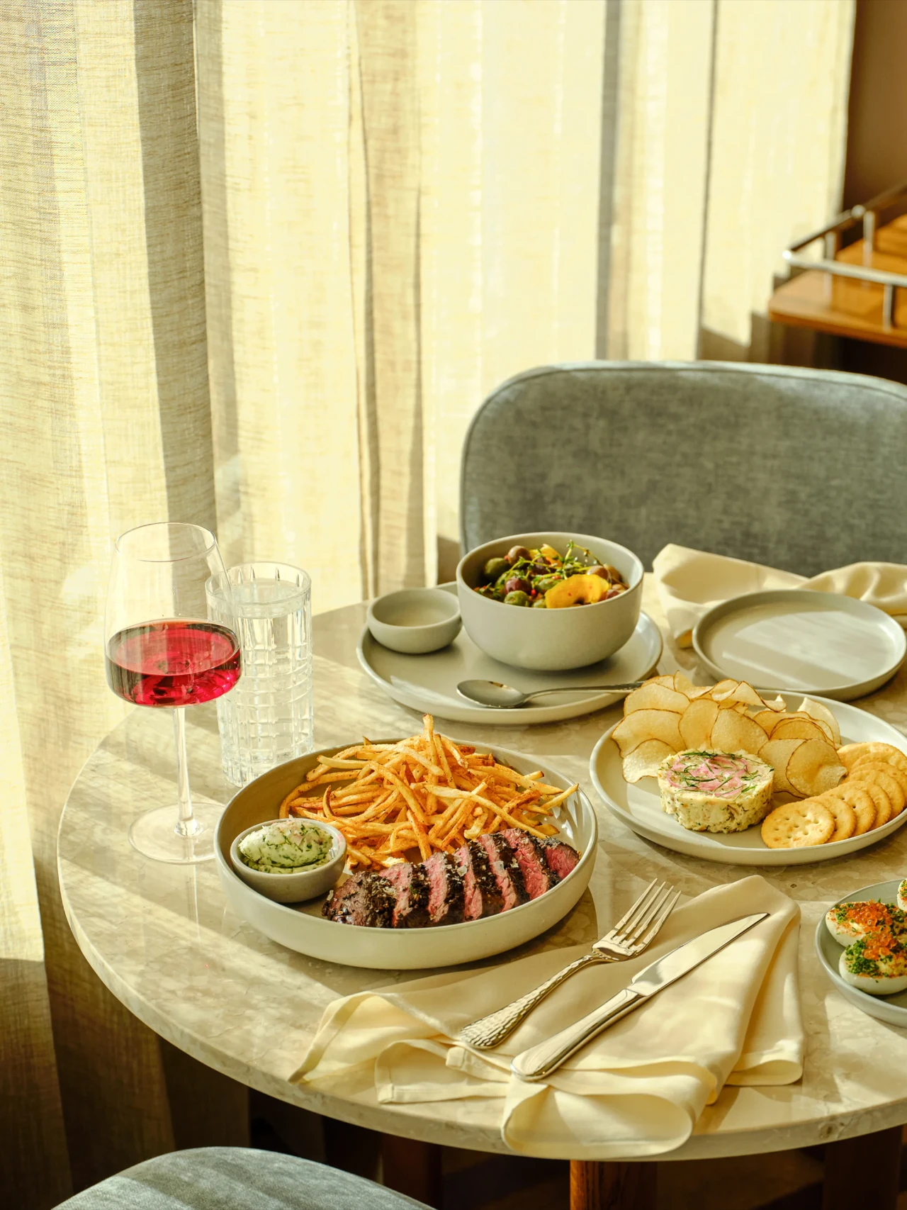 Steak frites, snacks and a glass of rosé on the marble tables at High Ground Lounge